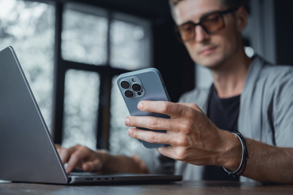 Homem utilizando aplicativo para programar transferência automática e guardar dinheiro